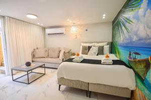 sypialnia z dużym łóżkiem i kanapą w obiekcie Yalarent Hawaii Complex Boutique & Garden Hotel Apartments Eilat w Ejlat