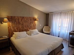 a bedroom with a large white bed and a window at Hôtel La Villa Tosca in Cannes