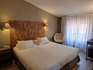 una camera da letto con un grande letto bianco e una finestra di Hôtel La Villa Tosca a Cannes
