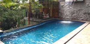 - une piscine d'eau bleue dans la cour dans l'établissement Maru fortuna Villa, à Tegalalang