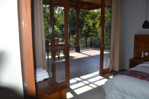 - une chambre avec un lit et un balcon avec une table dans l'établissement Maru fortuna Villa, à Tegalalang
