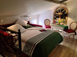 1 dormitorio con cama, mesa y espejo en Le petit nid d'aigle - Giverny en Giverny