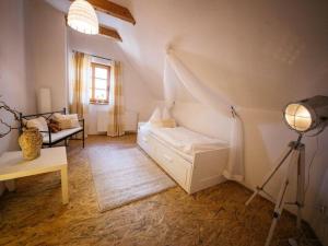 een witte kamer met een bed en een lamp bij Holiday Home amid the walking and cycling area of Petzenland in Unterlibitsch