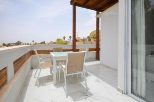 a patio with a table and chairs on a balcony at Yalarent Hawaii Complex Boutique & Garden Hotel Apartments Eilat in Eilat