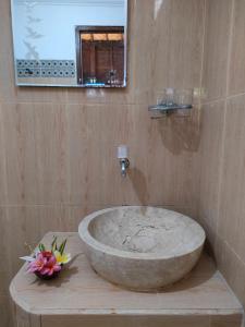 a bathroom with a large stone sink and a mirror at Exotic View Cottage in Nusa Penida