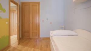 A bed or beds in a room at El Capricho de Ana - Apartamentos Aloha Toledo