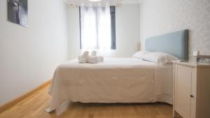 A bed or beds in a room at El Capricho de Ana - Apartamentos Aloha Toledo