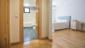 A bed or beds in a room at El Capricho de Ana - Apartamentos Aloha Toledo