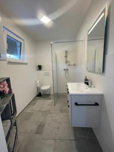 a white bathroom with a sink and a toilet at Sorinas Unterkunft WB16 Top 13 
