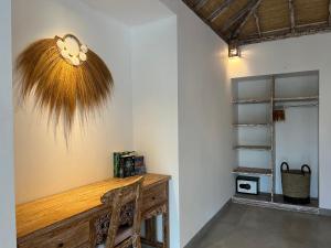 a room with a wooden desk with a fan on the wall at Santana Villas Bingin in Uluwatu