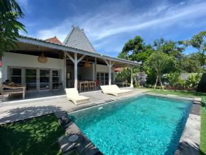 a villa with a swimming pool and a house at Santana Villas Bingin in Uluwatu
