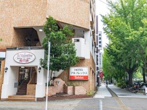 un edificio con un cartel en el costado en Tabist HotelArflex Tokuyama Station, en Shunan