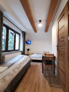 een slaapkamer met een bed, een bureau en een tafel bij Willa CIS in Karpacz