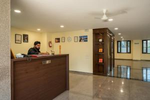 a man sitting at a reception desk in a lobby at Sheerha Royal Residency in Jaipur