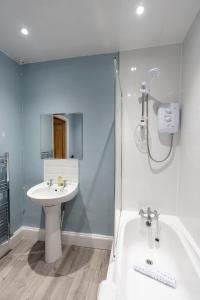 Un baño con bañera, lavabo y ducha. en Daffodil House, en Cockermouth