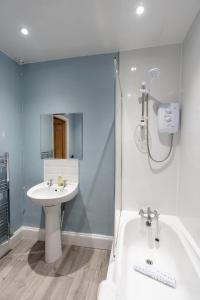 a bathroom with a tub and a sink and a shower at Daffodil House in Cockermouth