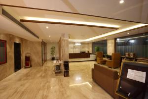 a lobby with a waiting room and a tv in it at Royal Plaza Suites in Mangalore