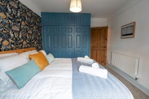 Schlafzimmer mit einem Bett mit blauer Wand in der Unterkunft Daffodil House in Cockermouth