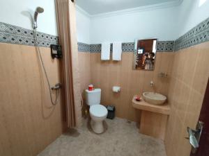 a bathroom with a toilet and a sink and a shower at Exotic View Cottage in Nusa Penida