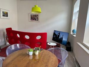 Good times in St. Goar (Mit Fahrrad-Keller) في سانكت غور: غرفة معيشة مع طاولة خشبية وكرسي احمر