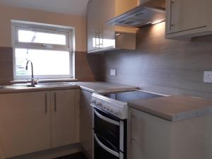 a small kitchen with a sink and a stove at Carvetii - Laurel House - 2 bed House sleeps up to 8 