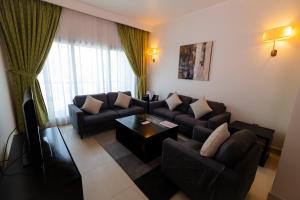 salon z kanapą i stołem w obiekcie Imperial Suites Hotel w mieście Doha