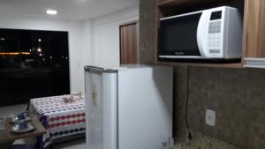 a kitchen with a refrigerator and a microwave at Maravilhoso FLAT 201 próximo Shopping Partage in Campina Grande