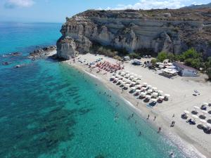 an aerial view of a beach with umbrellas and the ocean at Mirages in Tropea