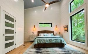 布罗肯鲍Key West Cottage的一间卧室，里面有一张床和一个吊扇 更多28张照片