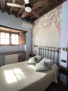 1 dormitorio con 1 cama con mapa en la pared en El Jardín del Convento, Casa Rural, en Hervás