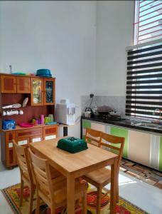 a kitchen with a wooden table and chairs at Noorsyah Homestay Stadium Utama in Kangar