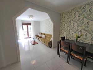 uma sala de estar com um sofá e uma mesa em Apartamentos Portonovo 3000 em Portonovo