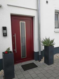 eine rote Tür an der Seite eines Gebäudes in der Unterkunft Villa Peony in Muhlheim am Main