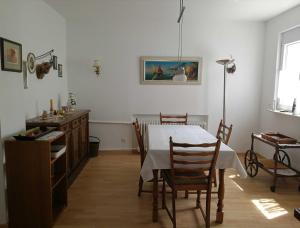 een eetkamer met een witte tafel en stoelen bij Villa Peony in Muhlheim am Main