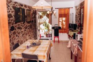 a dining room with a table and a kitchen at HILL HOUSE SANDALI 2 in Sitia