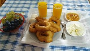 a plate of onion rings on a table with drinks at Green Forest in Berat