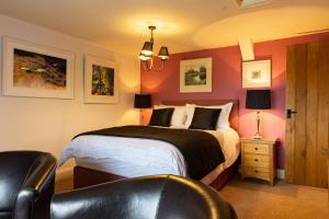 1 dormitorio con 1 cama y 1 silla en West Lyn Farm en Lynton