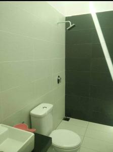 a bathroom with a white toilet and a sink at Noorsyah Homestay Stadium Utama in Kangar