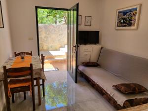 a living room with a couch and a table and a television at Apartments Jobst in Vela Luka