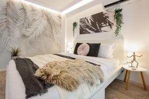 a bedroom with a white bed with a furry blanket on it at Modern Studios in Nerva Traian - Contemporary Living at Its Finest in Bucharest
