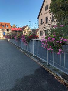 a fence with flowers on it next to a building at Chambre spacieuse dans joli village alsacien in Châtenois