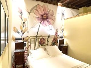 a bedroom with a bed with a flower mural on the wall at El Jardín del Convento, Casa Rural in Hervás