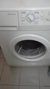 a washing machine with its door open in a kitchen at Room to rent-shared wc in Kavála