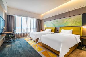 a hotel room with two beds and a desk at 敏卓酒店Mentor Hotel in Foshan