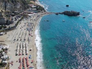 an aerial view of a beach with umbrellas and people at Mirages in Tropea