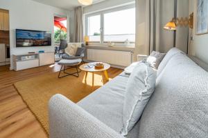 uma sala de estar com um sofá e uma televisão em Ankernest Ankernest em Westerland