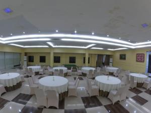 a banquet hall with white tables and white chairs at Anaya Hotel and Ballroom in Medan