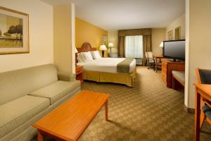 a hotel room with a bed and a couch at Holiday Inn Express Hotel & Suites Lenoir City Knoxville Area, an IHG Hotel in Lenoir City