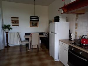 a kitchen with a white refrigerator and a table with chairs at Casa di Alice in Gorizia