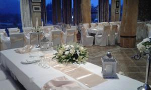 a table set up for a wedding with white tables and chairs at Djevojački Most in Kolašin